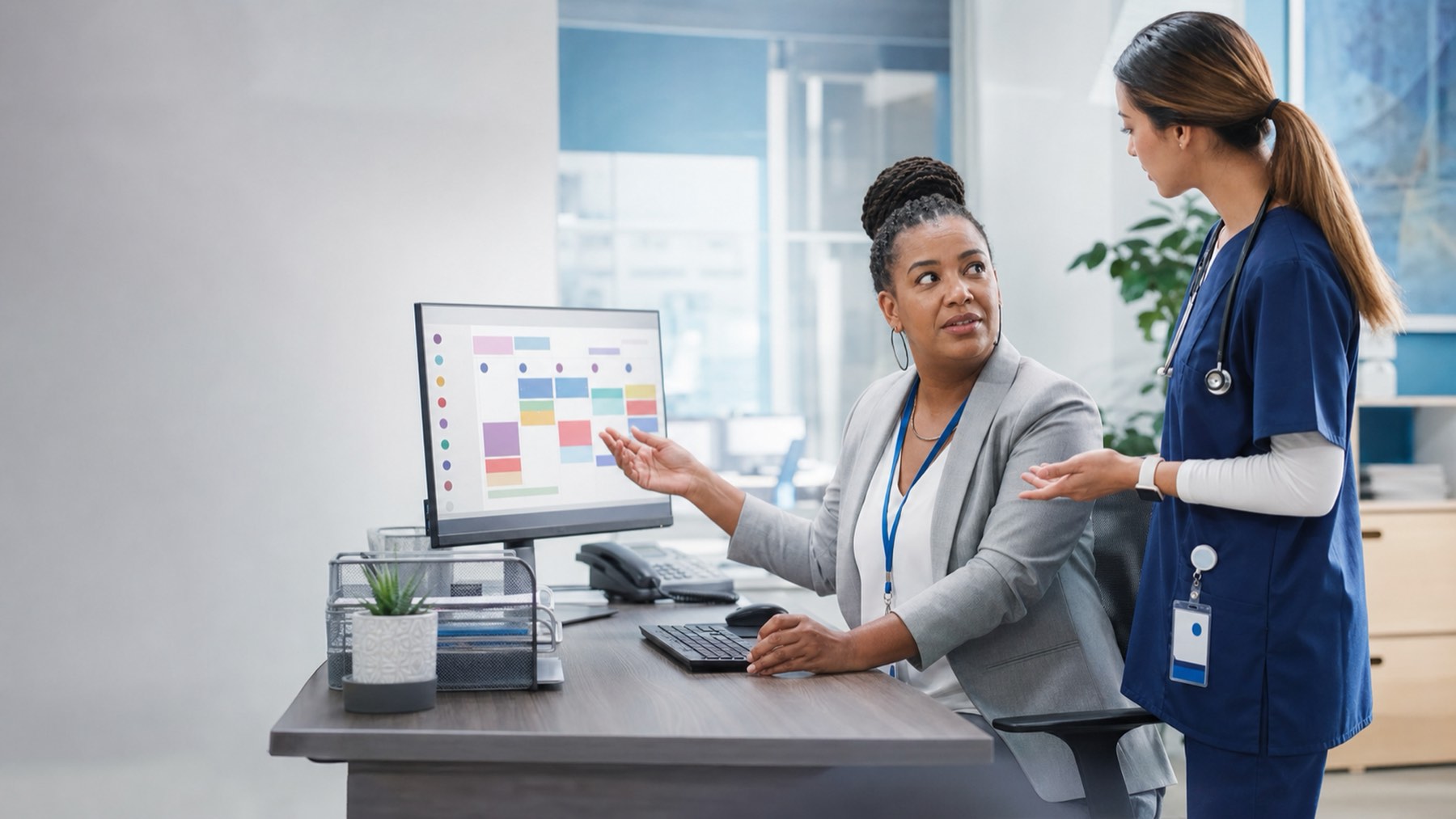 Healthcare staff reviewing a schedule at a computer